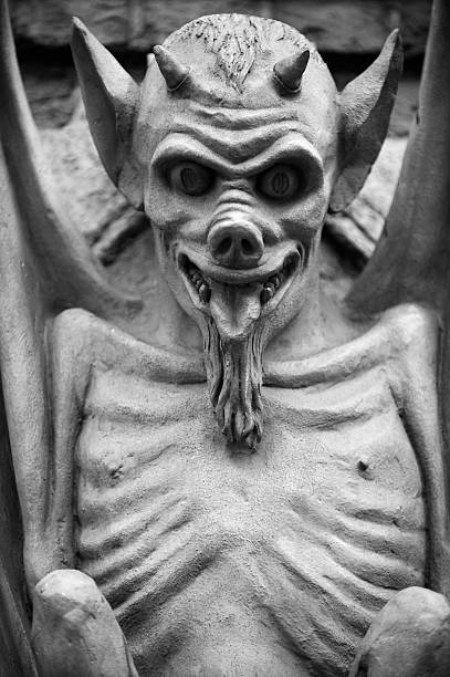 Gargoyle perched on a gothic cathedral making a creepy face
